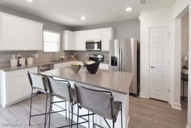 15827 Northridge Rd, Punta Gorda, FL 33982 - kitchen featuring stainless steel appliances, tasteful backsplash, a sink, a kitchen bar, and white cabinets
