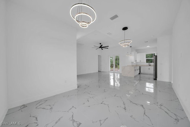 1205 W 14th St, Lehigh Acres, FL 33972 - unfurnished living room with a chandelier, light marble finish flooring, ceiling fan, and baseboards