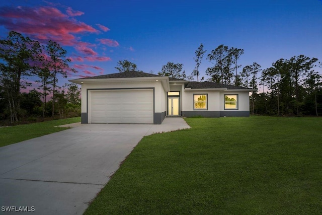 1205 W 14th St, Lehigh Acres, FL 33972 - view of front of home with driveway, an attached garage, stucco siding, and a yard