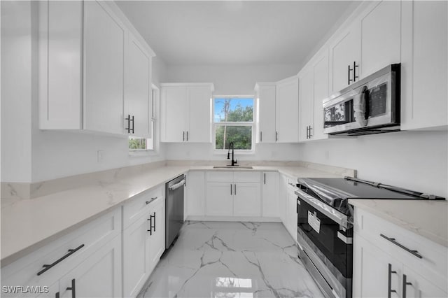 1205 W 14th St, Lehigh Acres, FL 33972 - kitchen featuring stainless steel appliances, light stone countertops, white cabinetry, and light marble finish flooring