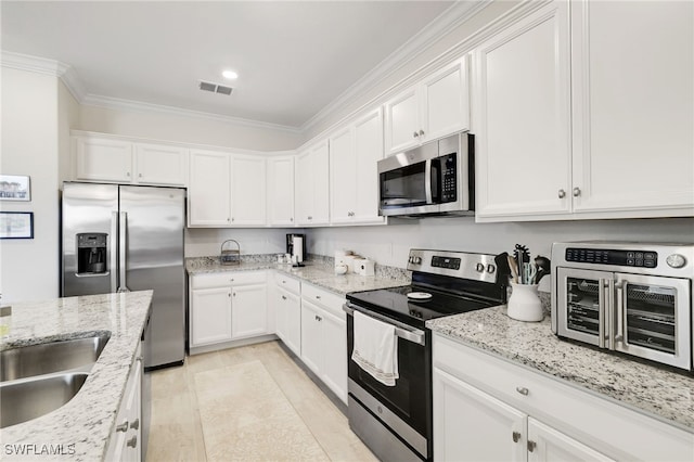 16126 Rosemallow Ln, Alva, FL 33920 - kitchen with appliances with stainless steel finishes, ornamental molding, white cabinets, and light stone countertops