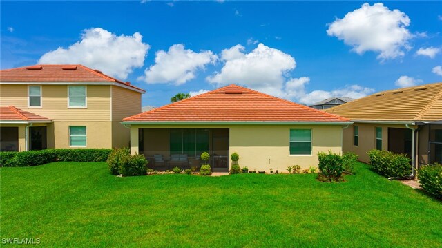 16126 Rosemallow Ln, Alva, FL 33920 - back of house featuring stucco siding, a sunroom, and a lawn