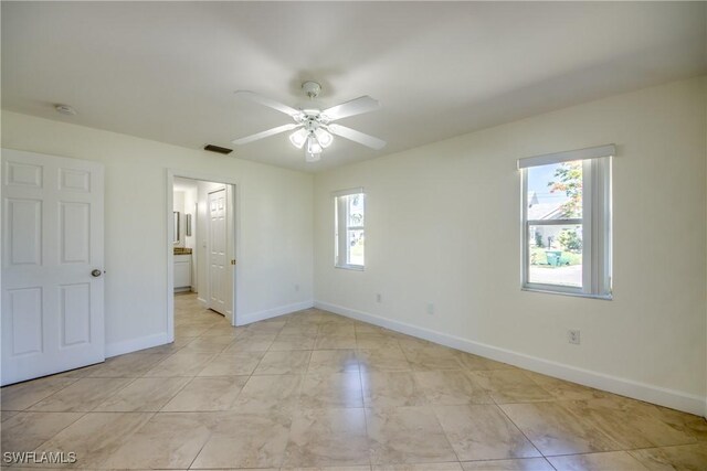 1101 SE 14th Ter, Cape Coral, FL 33990 - unfurnished bedroom featuring ceiling fan and ensuite bath