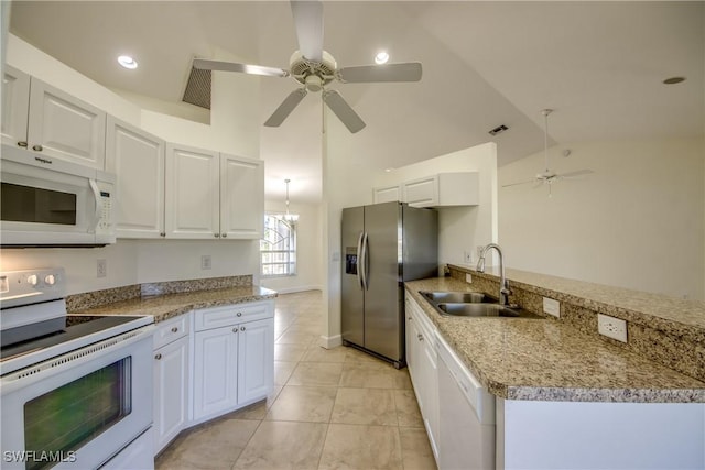 1101 SE 14th Ter, Cape Coral, FL 33990 - kitchen with white appliances, a ceiling fan, white cabinets, a peninsula, and light stone countertops