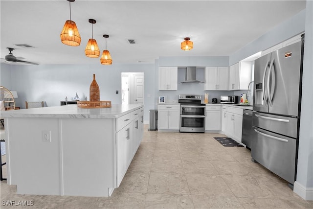 2317 El Dorado Pkwy W, Cape Coral, FL 33914 - kitchen featuring appliances with stainless steel finishes, wall chimney range hood, white cabinets, hanging light fixtures, and light countertops