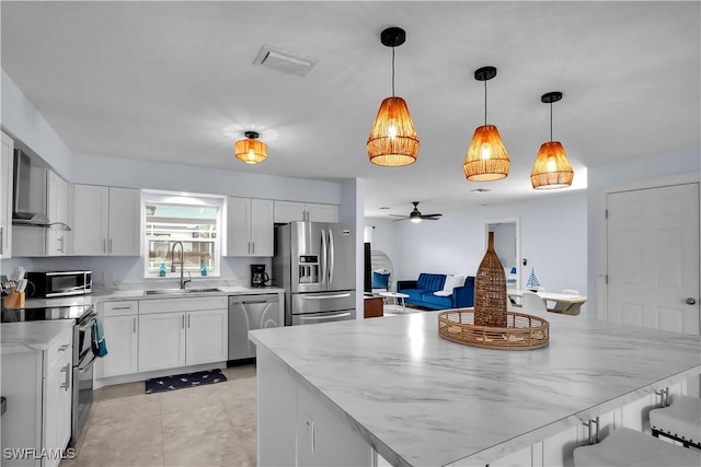 2317 El Dorado Pkwy W, Cape Coral, FL 33914 - kitchen featuring appliances with stainless steel finishes, a sink, white cabinetry, ceiling fan, and pendant lighting