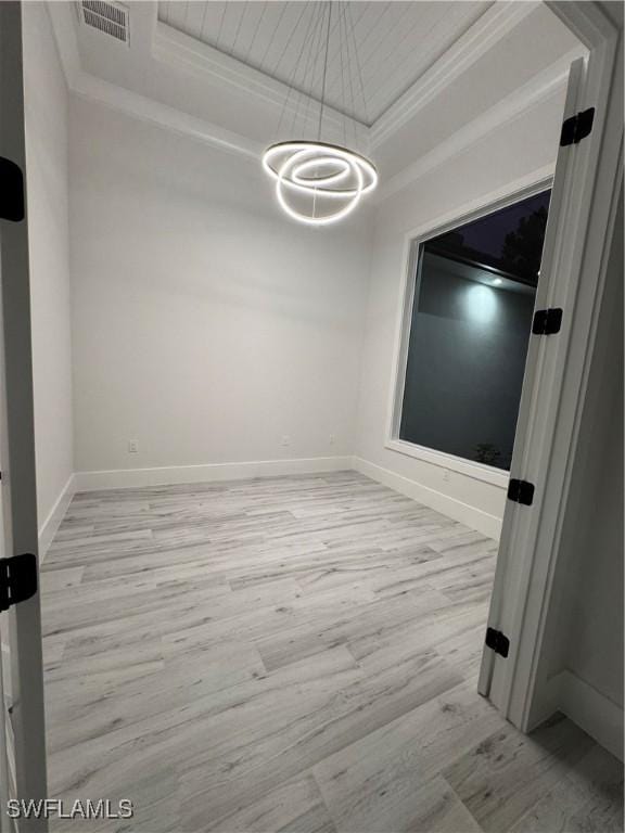 367 10th St NE, Naples, FL 34120 - unfurnished room featuring light wood-style floors, crown molding, a tray ceiling, and a chandelier