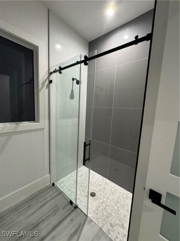 367 10th St NE, Naples, FL 34120 - bathroom with wood finished floors and a stall shower