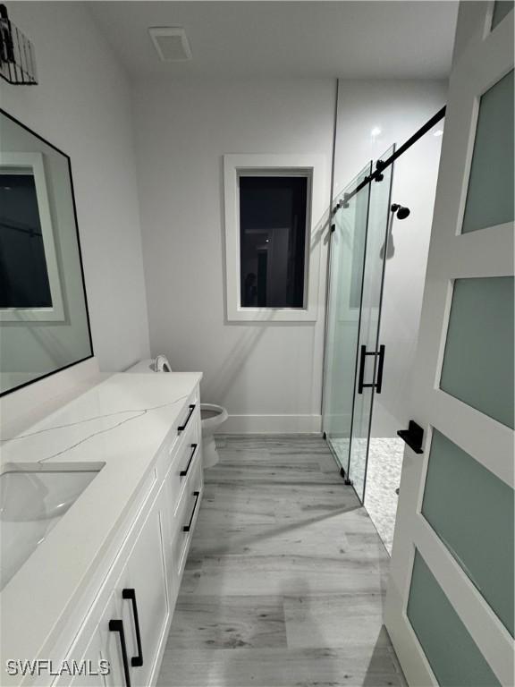 367 10th St NE, Naples, FL 34120 - full bath featuring vanity, a stall shower, and wood finished floors