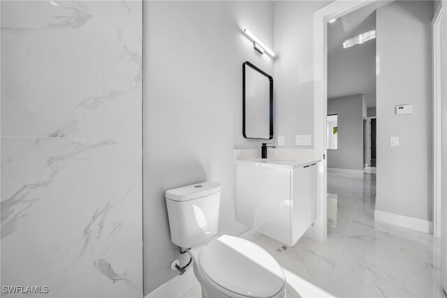 2512 10th St W, Lehigh Acres, FL 33971 - bathroom featuring marble tiled flooring, toilet, vanity, and baseboards