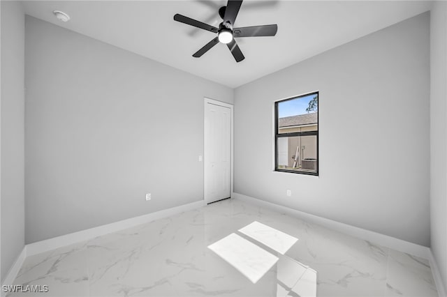 2512 10th St W, Lehigh Acres, FL 33971 - unfurnished bedroom with baseboards, light marble finish floors, and a ceiling fan