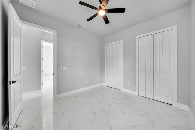 2512 10th St W, Lehigh Acres, FL 33971 - unfurnished bedroom with two closets, light marble finish flooring, and baseboards