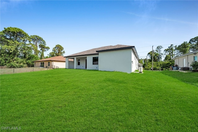 2512 10th St W, Lehigh Acres, FL 33971 - back of property featuring stucco siding and central AC unit
