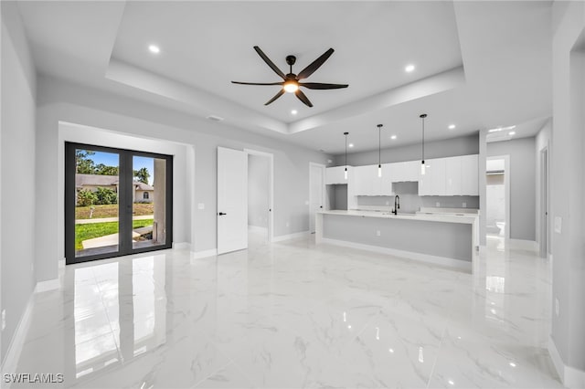 2512 10th St W, Lehigh Acres, FL 33971 - unfurnished living room featuring a raised ceiling, baseboards, recessed lighting, a ceiling fan, and light marble finish flooring