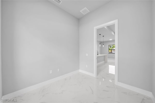 2512 10th St W, Lehigh Acres, FL 33971 - spare room featuring baseboards, light marble finish floors, and lofted ceiling