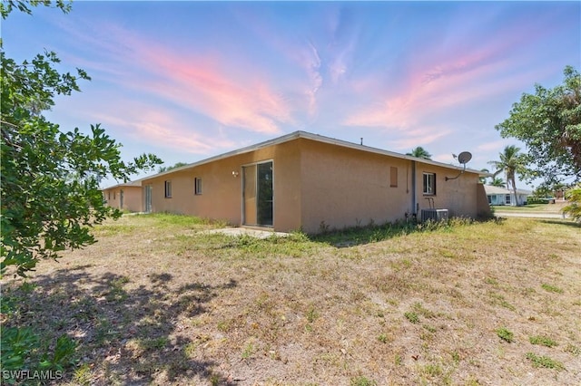 1423 SE 24th Ave, Cape Coral, FL 33990 - view of side of home with stucco siding and central AC unit