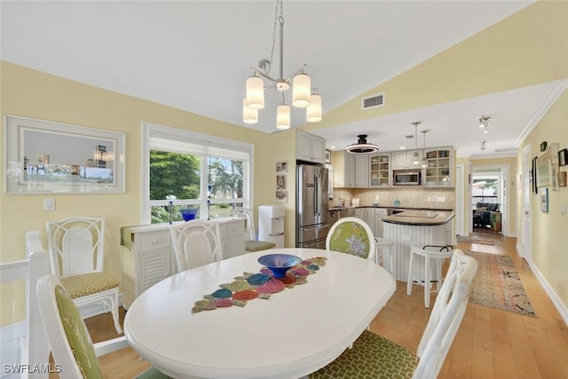 1043 Sand Castle Rd, Sanibel, FL 33957 - dining area with a chandelier, light wood-type flooring, and vaulted ceiling
