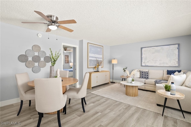 548 Broad Ave S Unit 548, Naples, FL 34102 - living area with a textured ceiling, light wood-style floors, a ceiling fan, and baseboards