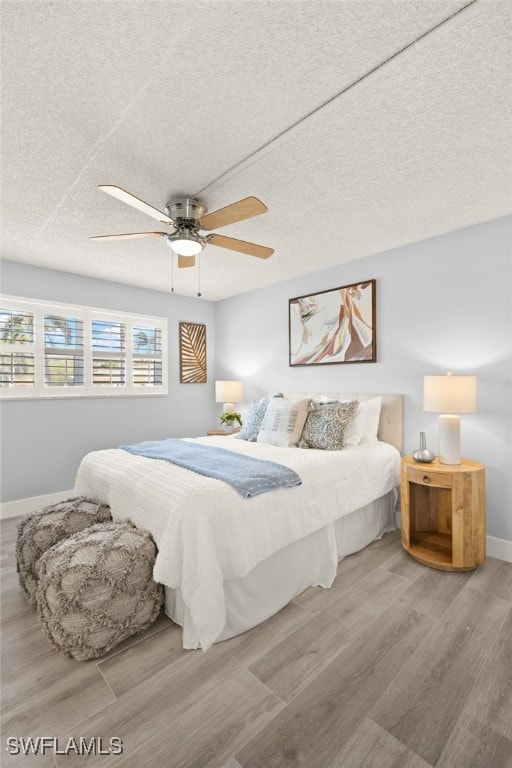 548 Broad Ave S Unit 548, Naples, FL 34102 - bedroom featuring wood finished floors, baseboards, a textured ceiling, and ceiling fan