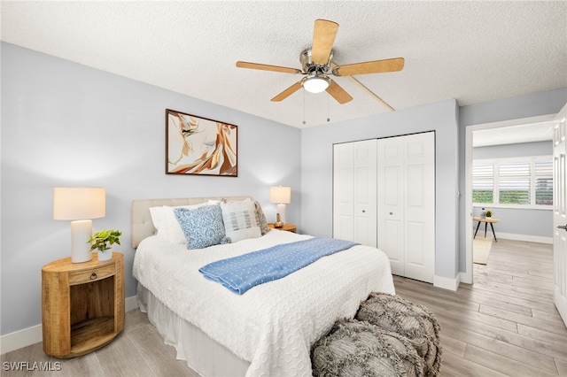 548 Broad Ave S Unit 548, Naples, FL 34102 - bedroom featuring light wood-style flooring, a closet, a textured ceiling, baseboards, and ceiling fan