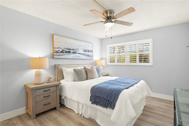 548 Broad Ave S Unit 548, Naples, FL 34102 - bedroom with light wood-style flooring, baseboards, a textured ceiling, and ceiling fan
