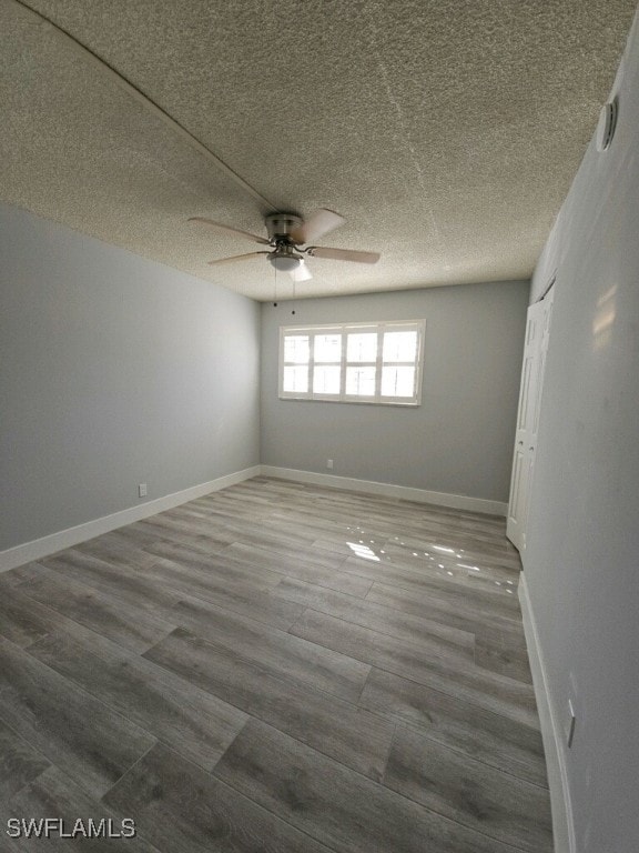 548 Broad Ave S Unit 548, Naples, FL 34102 - empty room with a ceiling fan, wood finished floors, a textured ceiling, and baseboards