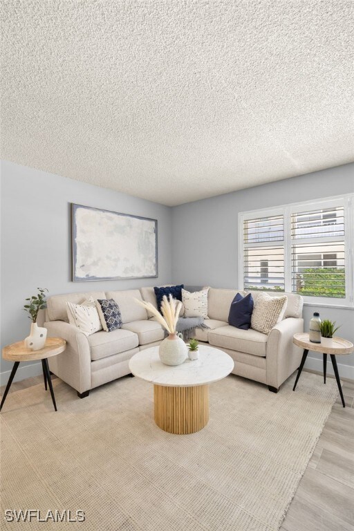 548 Broad Ave S Unit 548, Naples, FL 34102 - living area featuring a textured ceiling, baseboards, and light wood-style floors