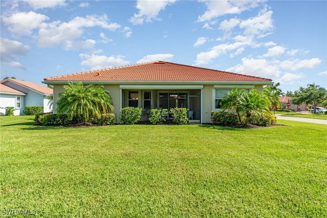 3130 Scarlet Oak Pl, North Fort Myers, FL 33903 - back of property with a tiled roof, a lawn, and stucco siding