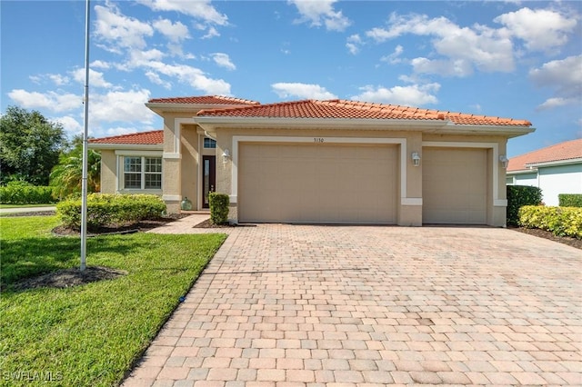 3130 Scarlet Oak Pl, North Fort Myers, FL 33903 - mediterranean / spanish-style house with decorative driveway, stucco siding, a garage, a tiled roof, and a front lawn