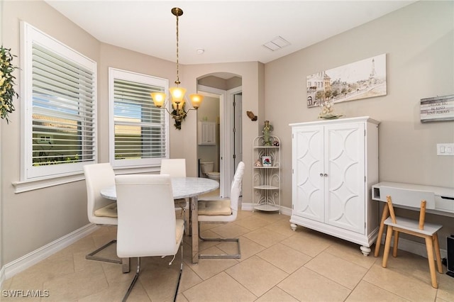 3130 Scarlet Oak Pl, North Fort Myers, FL 33903 - dining space with a chandelier, arched walkways, and light tile patterned floors