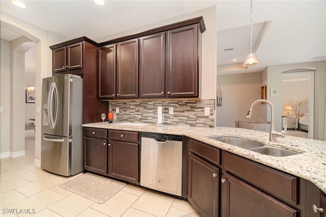 3130 Scarlet Oak Pl, North Fort Myers, FL 33903 - kitchen featuring appliances with stainless steel finishes, arched walkways, light tile patterned flooring, dark brown cabinets, and recessed lighting