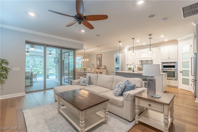 6848 Winding Cypress Dr, Naples, FL 34114 - living area featuring ceiling fan, crown molding, recessed lighting, light wood-style flooring, and baseboards