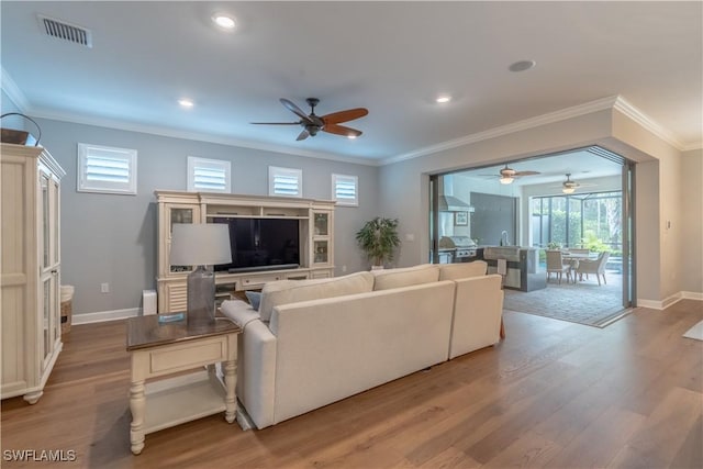 6848 Winding Cypress Dr, Naples, FL 34114 - living room with ceiling fan, wood finished floors, crown molding, baseboards, and recessed lighting