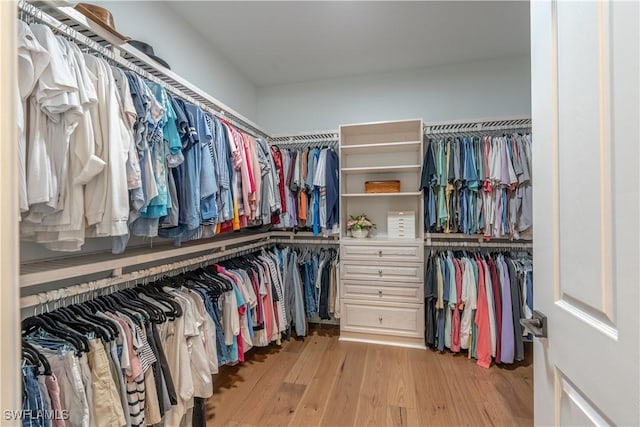 6848 Winding Cypress Dr, Naples, FL 34114 - walk in closet featuring wood finished floors