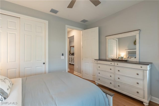 6848 Winding Cypress Dr, Naples, FL 34114 - bedroom with wood finished floors, baseboards, a ceiling fan, and a closet