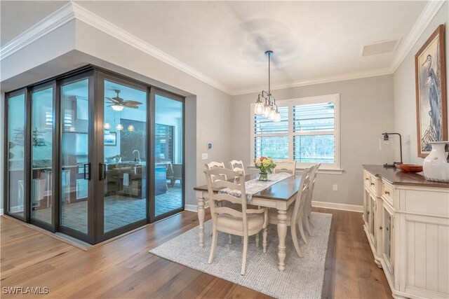 6848 Winding Cypress Dr, Naples, FL 34114 - dining space featuring dark wood-style flooring, baseboards, crown molding, and a chandelier