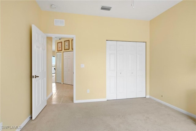 25057 Peacock Ln Unit 202, Naples, FL 34114 - unfurnished bedroom with light carpet, baseboards, and a closet