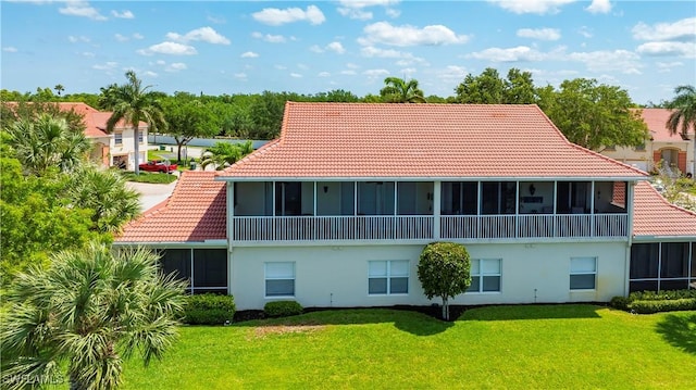 25057 Peacock Ln Unit 202, Naples, FL 34114 - back of property with a sunroom, a tiled roof, a yard, and stucco siding