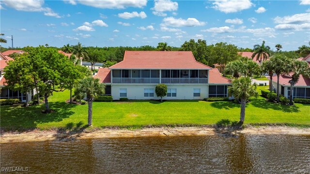 25057 Peacock Ln Unit 202, Naples, FL 34114 - back of property with a water view, a tile roof, a sunroom, and a yard