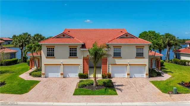 25057 Peacock Ln Unit 202, Naples, FL 34114 - view of front of property featuring a garage, driveway, stucco siding, and a front yard