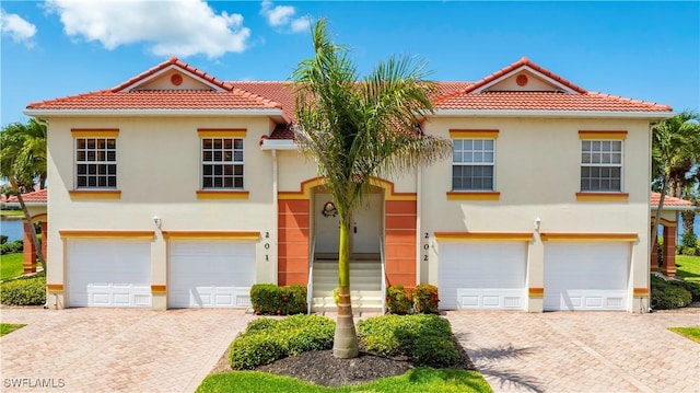 25057 Peacock Ln Unit 202, Naples, FL 34114 - view of front facade featuring a garage, driveway, and a tile roof