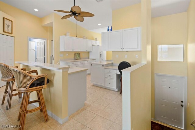 25057 Peacock Ln Unit 202, Naples, FL 34114 - kitchen featuring a peninsula, a breakfast bar, white refrigerator with ice dispenser, ceiling fan, and recessed lighting
