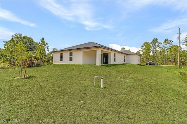 365 Woodburn Dr, Lehigh Acres, FL 33972 - rear view of house featuring a yard and stucco siding