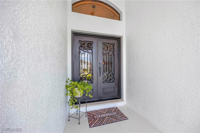 520 Raven Way, Naples, FL 34110 - view of exterior entry with french doors and stucco siding