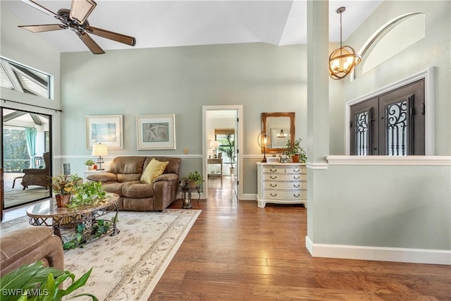 520 Raven Way, Naples, FL 34110 - living room with a towering ceiling, hardwood / wood-style floors, a chandelier, ceiling fan, and baseboards