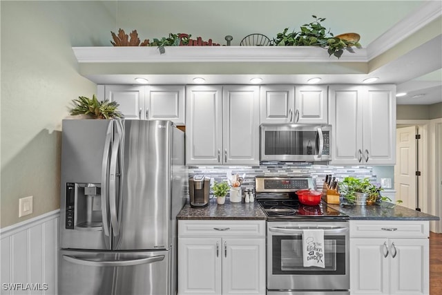 520 Raven Way, Naples, FL 34110 - kitchen featuring appliances with stainless steel finishes, white cabinets, tasteful backsplash, wainscoting, and dark stone countertops