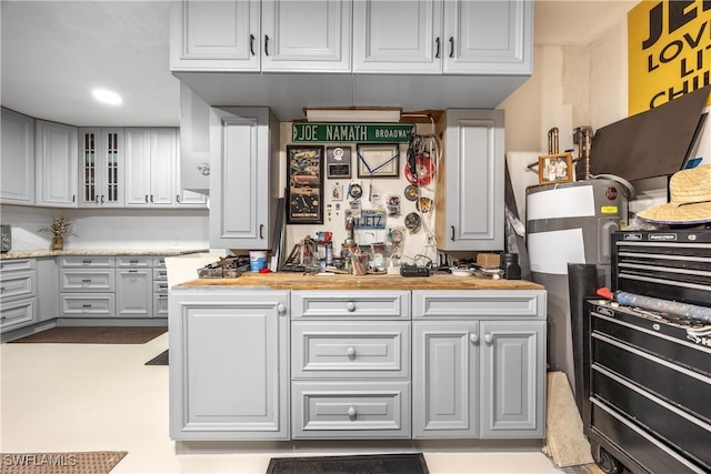 520 Raven Way, Naples, FL 34110 - kitchen featuring glass insert cabinets, white cabinets, and wood counters