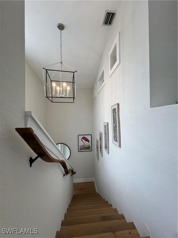 7087 Barrington Cir Unit 201, Naples, FL 34108 - staircase with a chandelier, wood finished floors, and baseboards