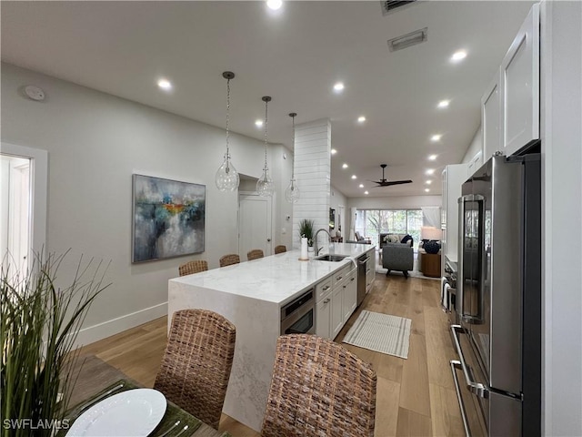 7087 Barrington Cir Unit 201, Naples, FL 34108 - kitchen featuring appliances with stainless steel finishes, a sink, open floor plan, a ceiling fan, and a large island