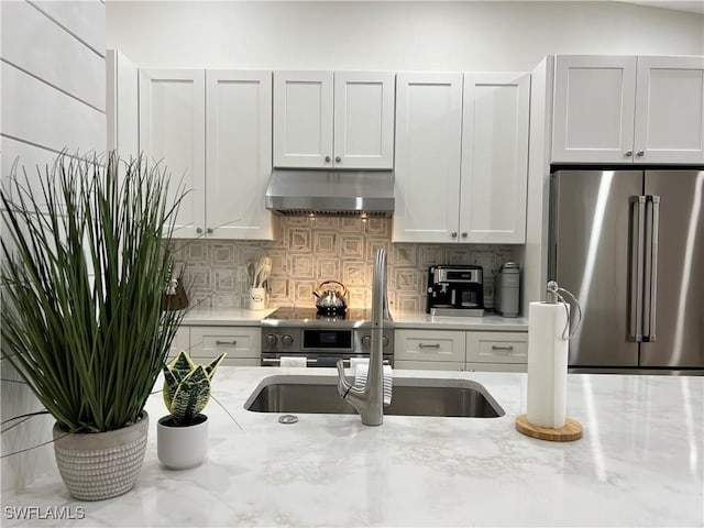 7087 Barrington Cir Unit 201, Naples, FL 34108 - kitchen featuring appliances with stainless steel finishes, exhaust hood, backsplash, and light stone counters